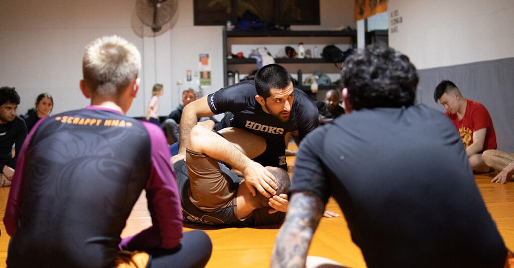 Coach teaching jiu jitsu to class